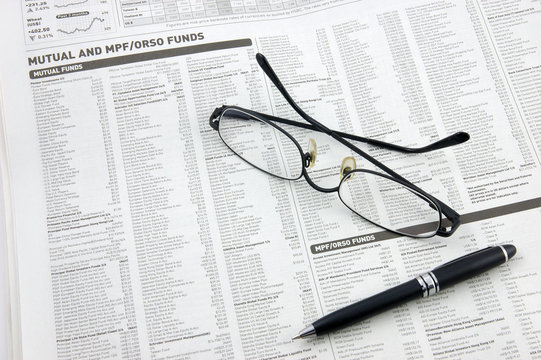 glasses, pen and mutual funds on newspaper