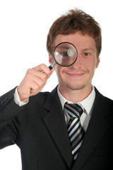 Obraz na płótnie Canvas businessman holding magnifying glass