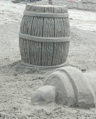 sand sculpture of pirate's powder keg and cannon
