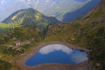 Fototapeta na wymiar Alpy z niewielkim jeziorem i hut