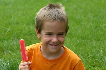 boy holding popsicle with grin