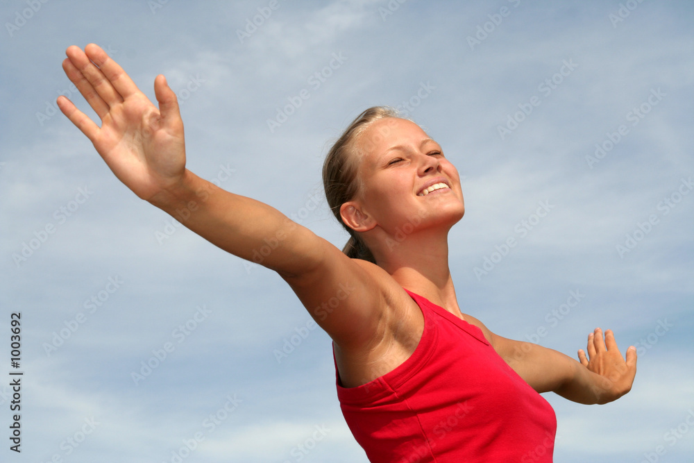 Wall mural happy young woman with arms outstretched - Wall murals