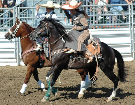 two mexican cowgirls on horseback