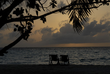 beach-lits on a maldivian island at sunset