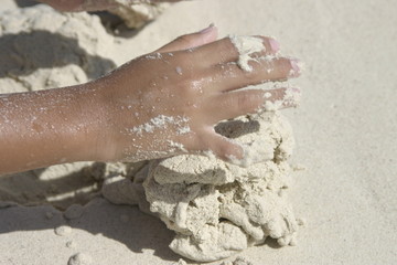 manos jugando en la arena