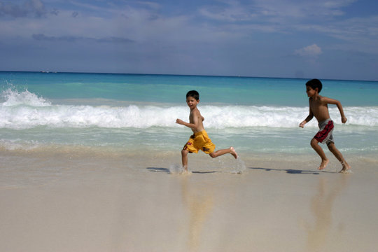 ni&ntilde;os corriendo en la playa