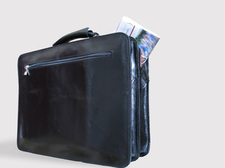 a casual briefcase and a newspaper inside it