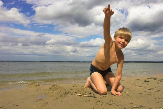 boy, sea and cloudy sky