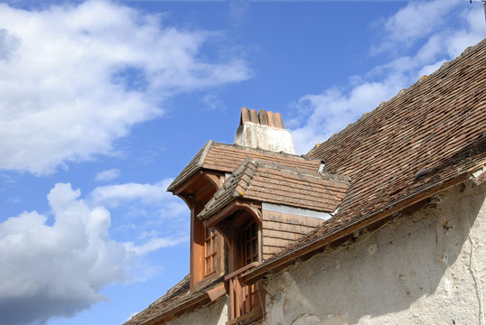 deux lucarnes dans une toiture sous un ciel bleu