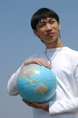 young asian man with a globe