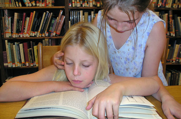 two girls studying a book