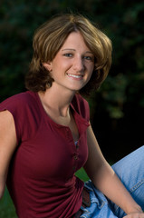 head shot of smiling young woman outdoors