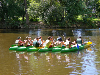 seven canoes with young people in the river