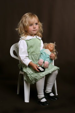 cute little girl in green dress with doll