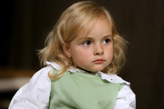 cute little serious angel in green dress