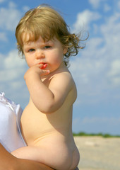 Petit enfant nu dans les bras de sa maman