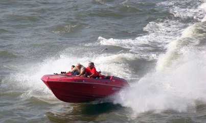 Fototapeten men in speed boat on water © Ben Keith