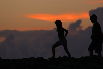 Fototapeta na wymiar silhouettes of people walking in front of sunset
