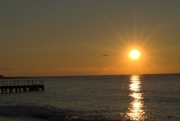 Fototapeta na wymiar sunrise on black sea with pier silhouette