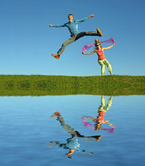 couples jump on grass and water