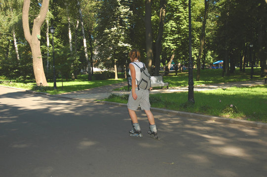 girl on roller-blades skating across the park