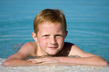 jeune garcon au bord de la piscine