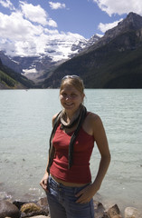 happy young woman in front of lake louise - banff national park,