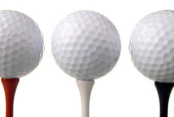 three golf balls on tees