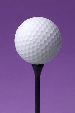 golf ball on blue tee, purple background