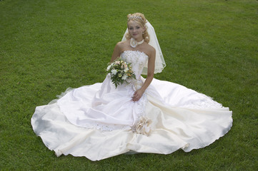 the fine bride sits on a meadow.