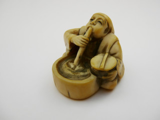 tiny figurine of an opium smoker