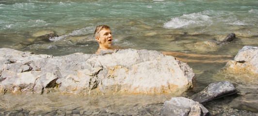 middle-aged man bathing in a cold mountain-stream
