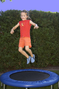 junges m&auml;dchen h&uuml;pft auf dem trampolin