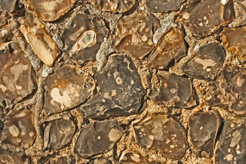 Close-up section of a traditional flint-built wall showing detailed stone texture and craftsmanship.