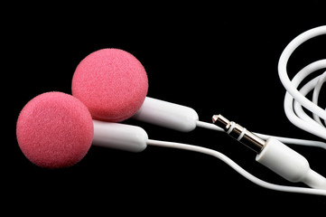 pink earbuds closeup, macro, on black