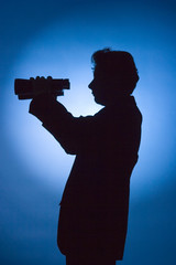 silhouette of man with binoculars