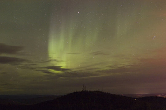 vivid aurora borealis through clouds