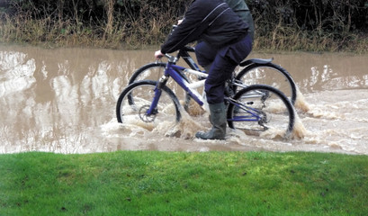 boys cycling through flood