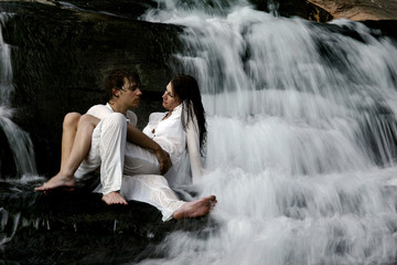 couple sitting in waterfall