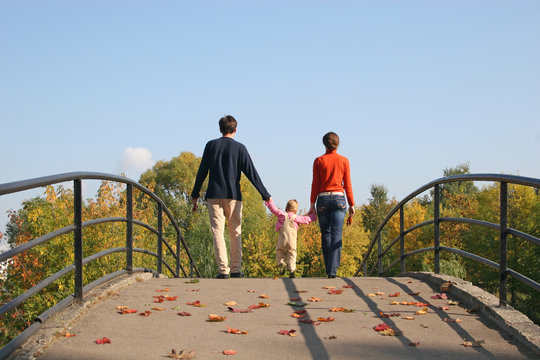 behind family with baby on autumn bridge