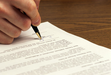 man signs document