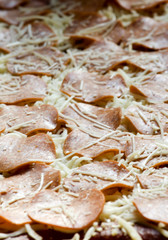 a sheet of uncooked pepperoni pizza