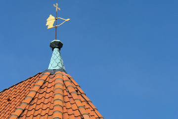 Fototapeta na wymiar wetterfahne auf rotem dach