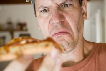Photo sur Plexiglas Pizzeria homme mangeant une pizza au pepperoni