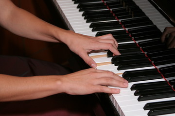 hands playing piano keys