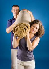 man and woman with rolled carpet