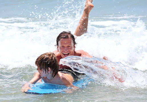 young father and son learning to surf