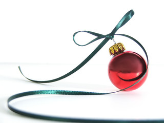 red ornament with swirling ribbon