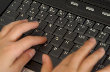 close-up of fingers typing on a computer keyboard