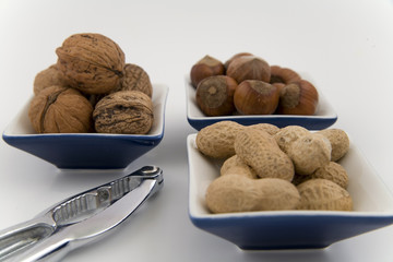 walnuts, hazelnuts and peanuts in three bowls